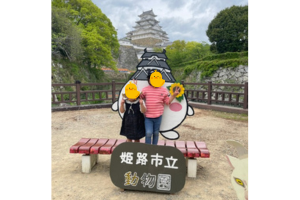 姫路市立動物園で姫路城をバックに写真を撮る子ども